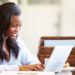 happy woman working on laptop computer - how much should pest control cost