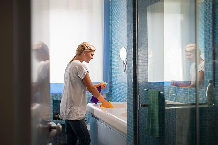 woman cleaning bathroom in home