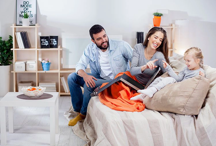 family laughing on the couch in their home